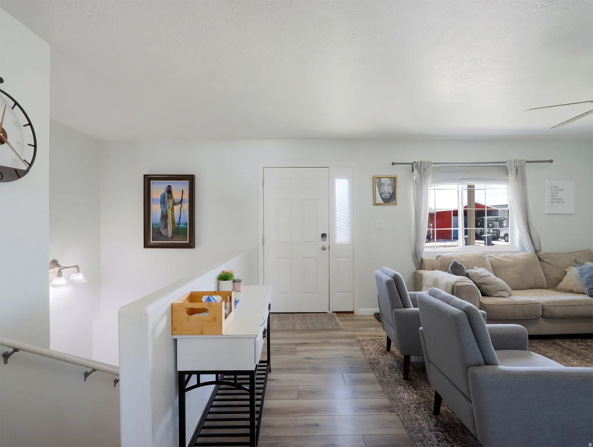 Entryway featuring wood-finish flooring, a white front door with decorative glass sidelight, and a built-in wall sconce