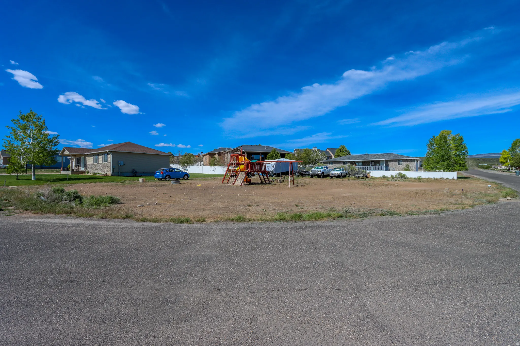 Spacious corner lot featuring a mature tree and partial fencing