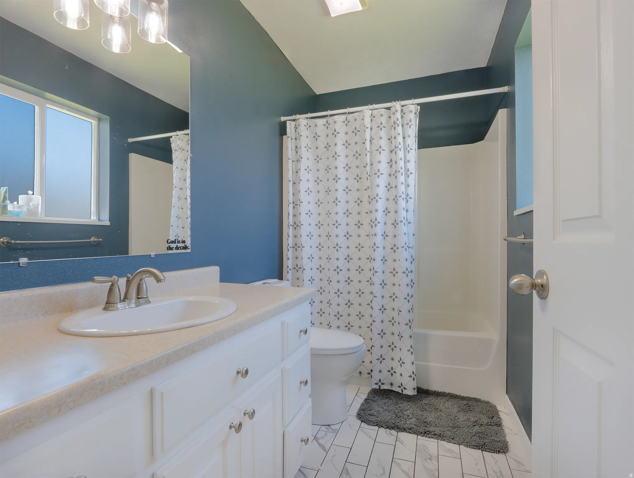 Bathroom featuring a white vanity with an oval sink, brushed nickel faucet, and a light-colored countertop