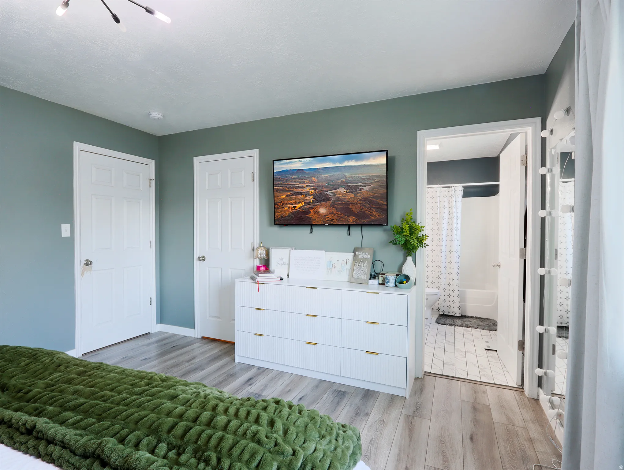Bedroom featuring wood-finish flooring and a contemporary light fixture