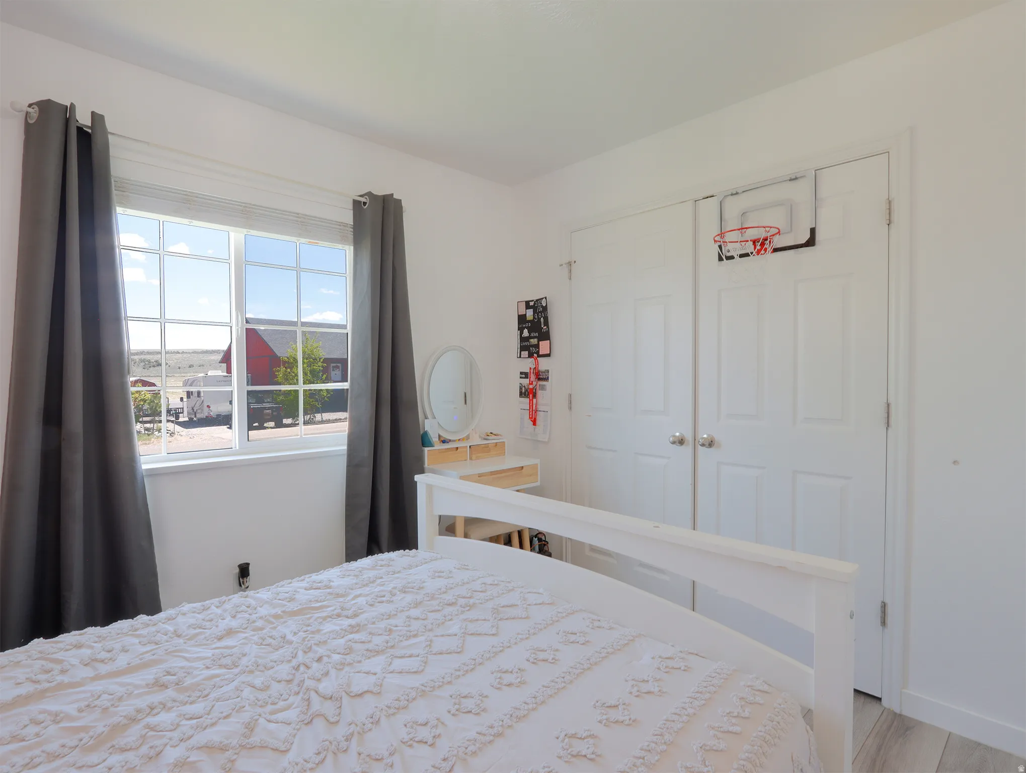 Bedroom featuring white walls and a large window with grid panes