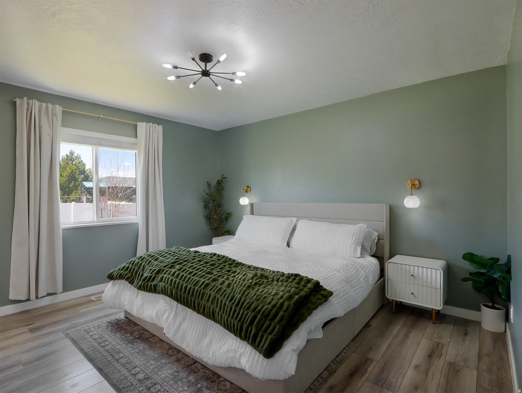 Spacious bedroom with wood-finish flooring, a contemporary sputnik chandelier, and recessed window