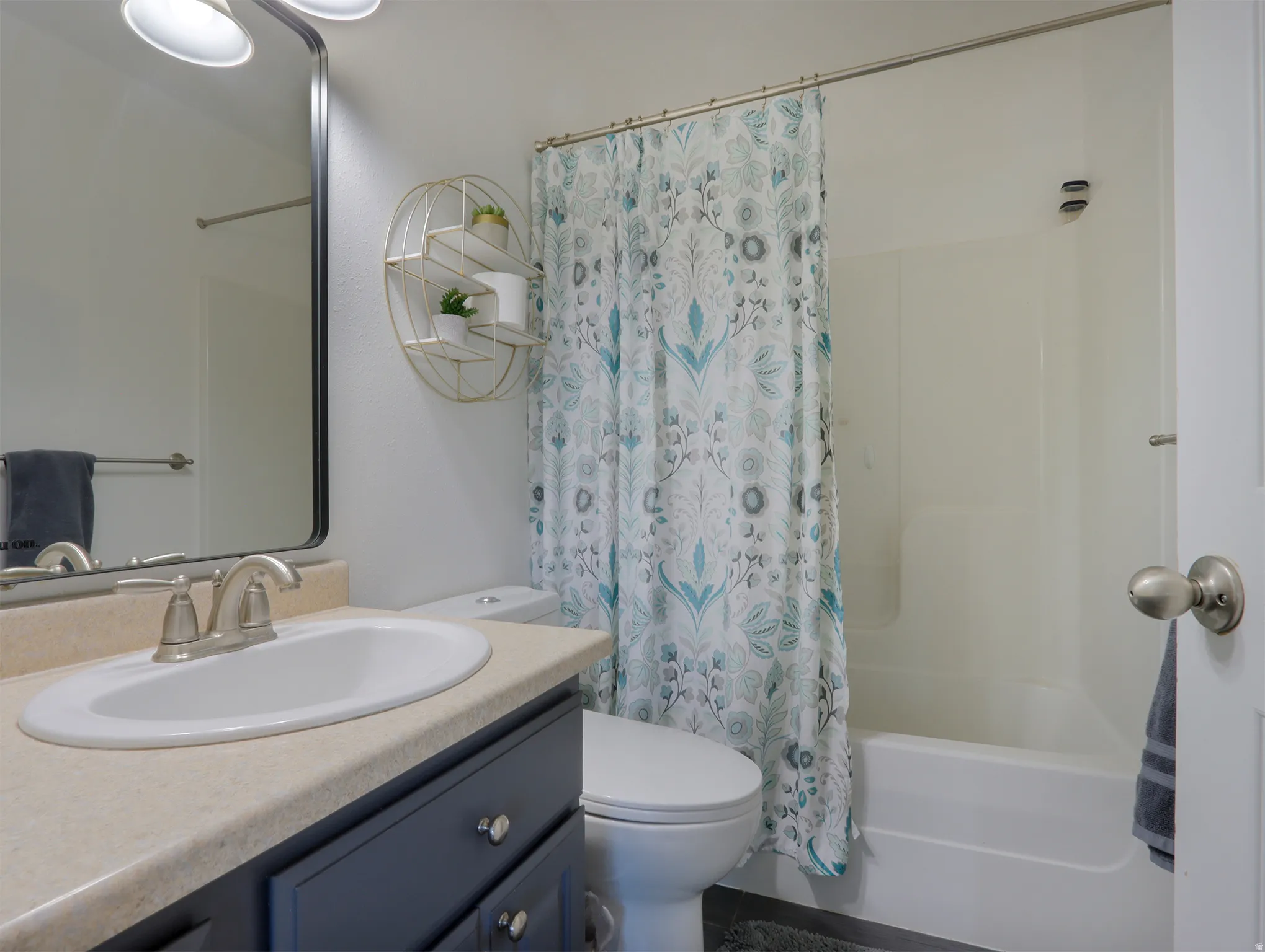 Bathroom featuring a single vanity with an oval basin, brushed nickel faucet, and dark cabinetry