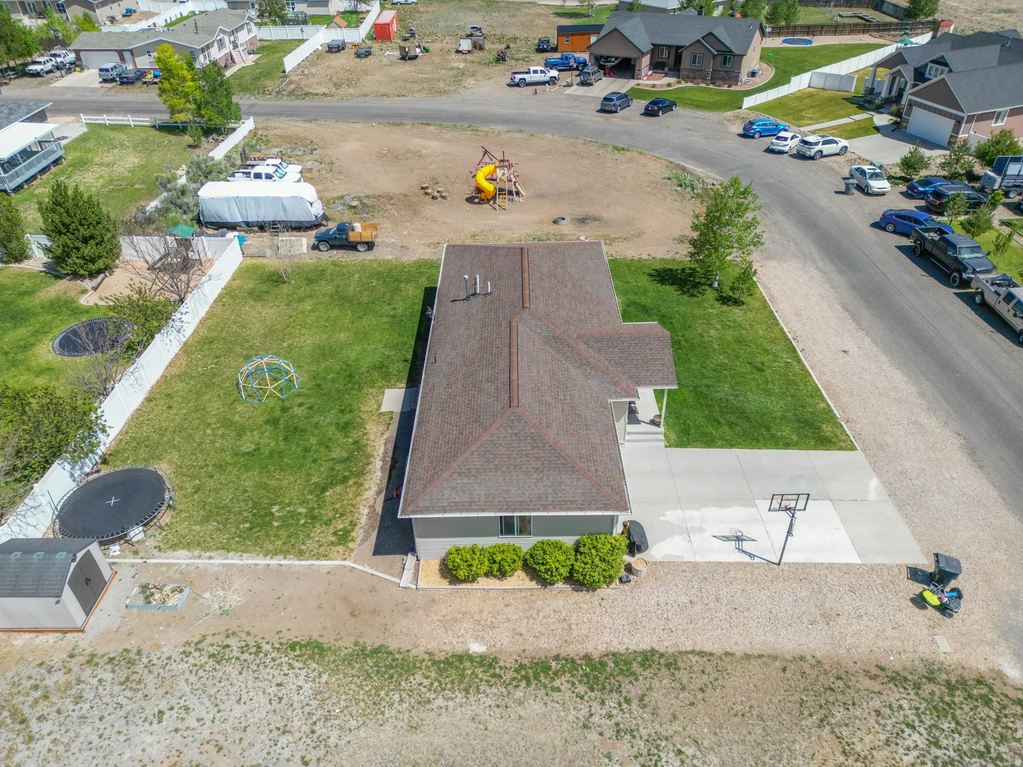 Single-story residence featuring a covered front porch, a paved driveway, and a basketball hoop