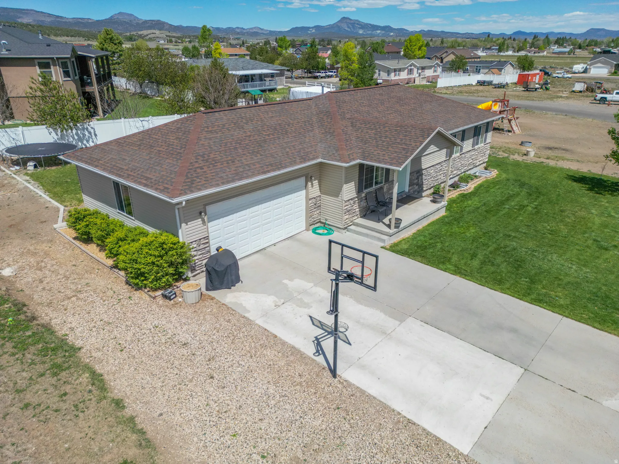Ranch-style exterior featuring a covered porch, attached garage with a white sectional door, and concrete driveway