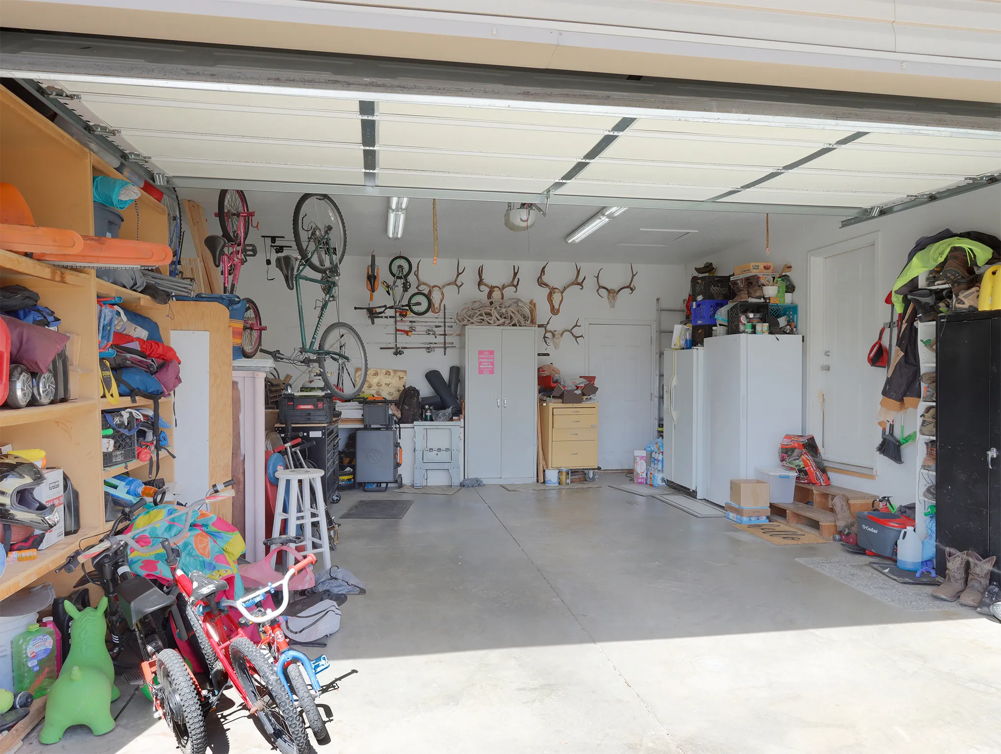 Spacious garage with concrete flooring, overhead lighting, and white walls