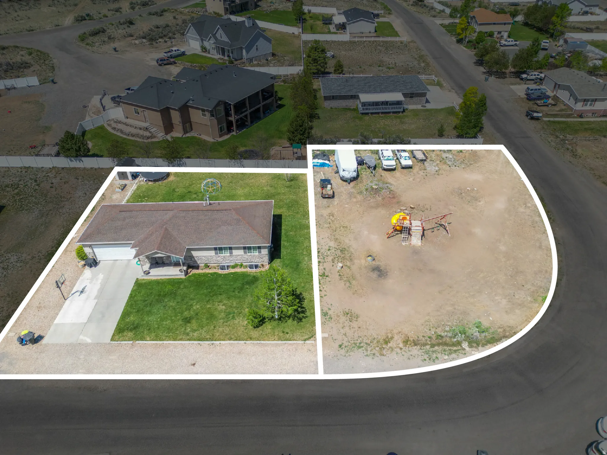Aerial view showcasing a residential property with an accompanying undeveloped parcel