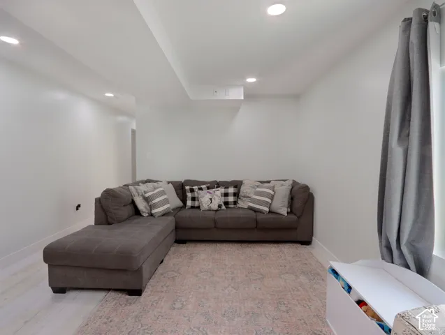 Spacious interior area featuring recessed lighting, a window with drapery, and light-toned wood-finish flooring