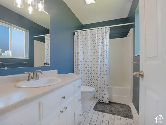 Bathroom featuring a white vanity with an oval sink, brushed nickel faucet, and a light-colored countertop