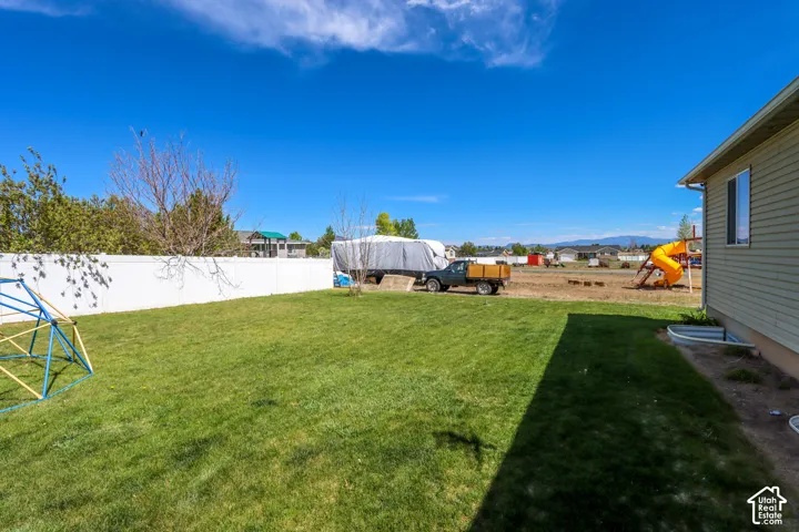 Expansive green lawn framed by a white privacy fence