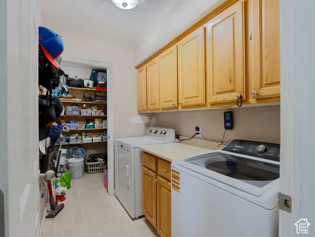 Laundry room featuring extensive upper cabinetry, a solid surface countertop, and tiled flooring