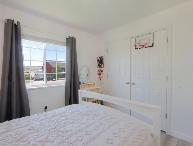 Bedroom featuring white walls and a large window with grid panes