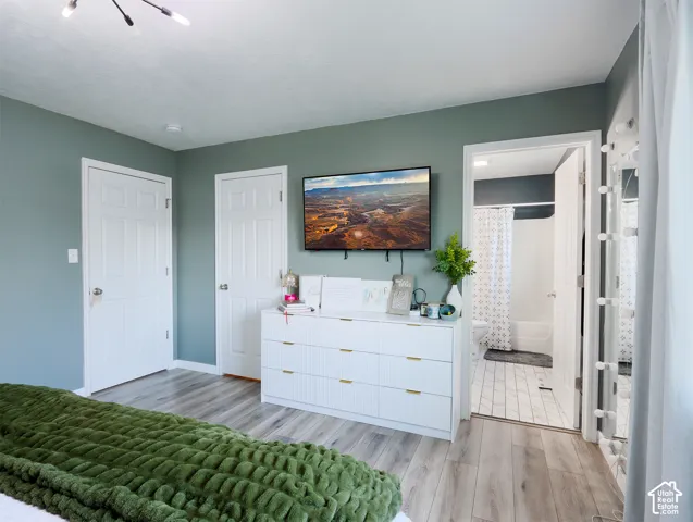 Bedroom featuring wood-finish flooring and a contemporary light fixture