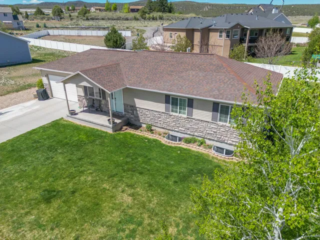 Ranch-style residence featuring a stone and siding exterior, brown shingle roof, and an attached two-car garage