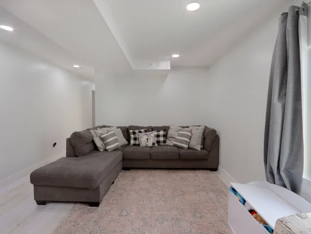 Spacious interior area featuring recessed lighting, a window with drapery, and light-toned wood-finish flooring