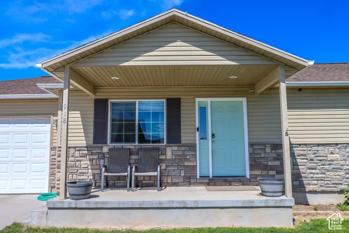 Property exterior featuring stone veneer accents, light beige siding, and a covered porch