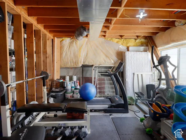 Unfinished basement space featuring exposed wood joists and structural beams, concrete foundation walls, and visible ductwork