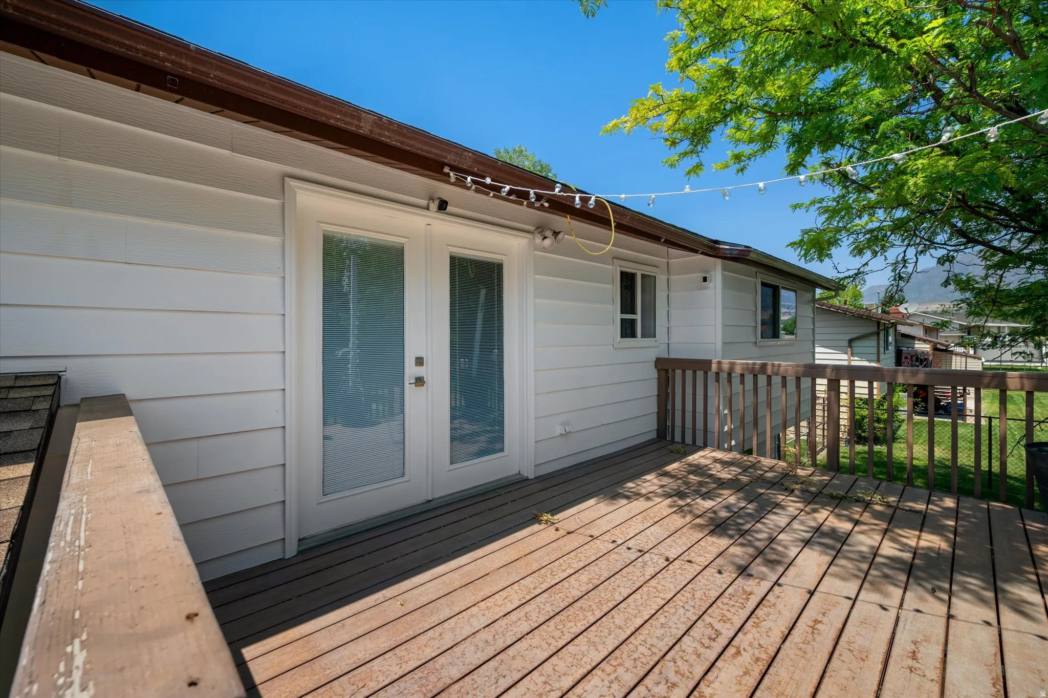 Expansive wood deck with a full wood railing and direct access via double French doors
