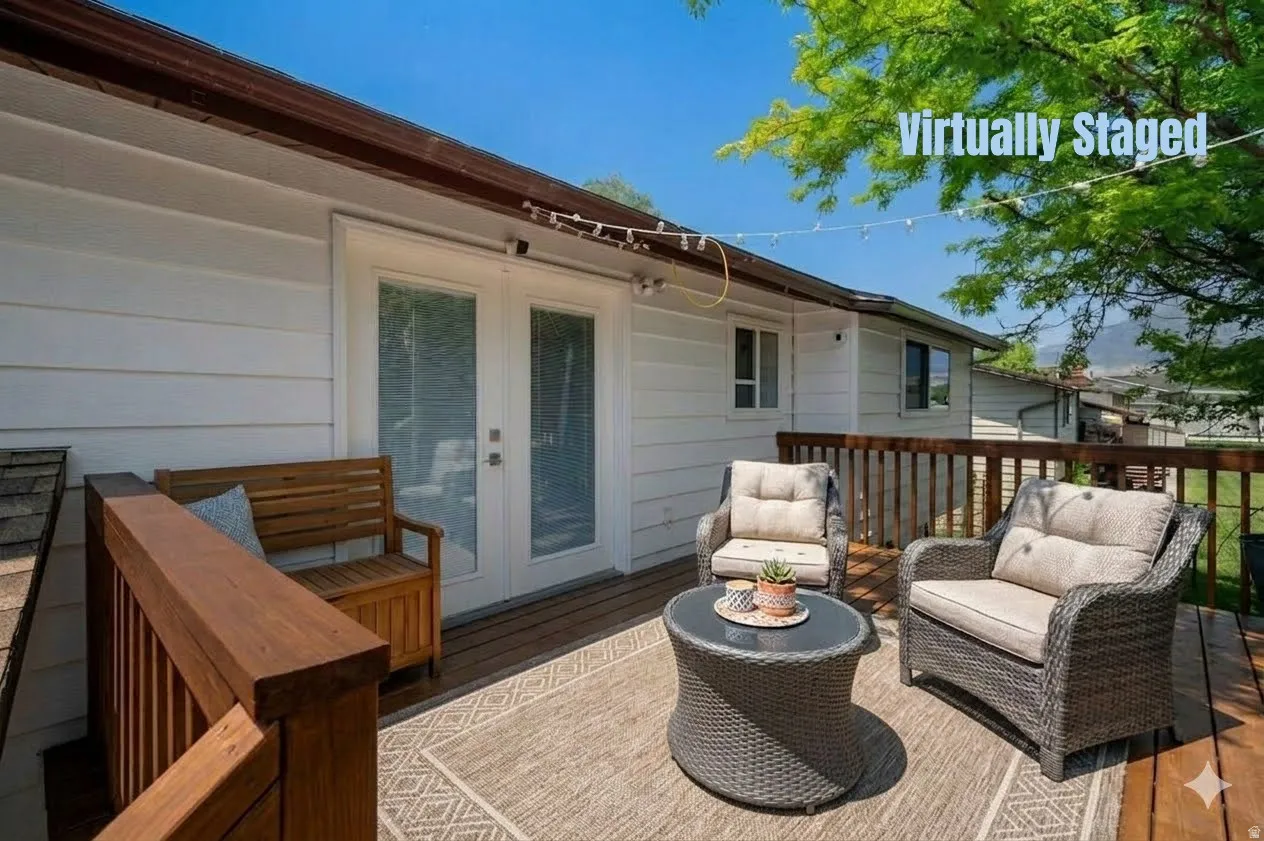 Expansive exterior deck featuring a wood railing and white siding