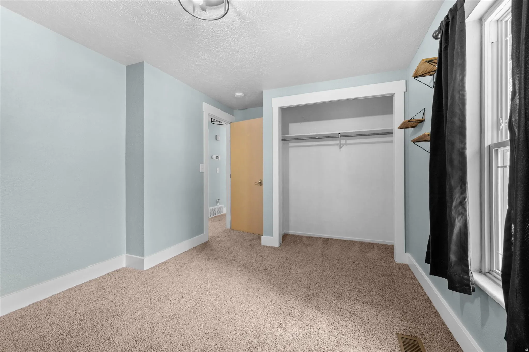 Bedroom #2 featuring light blue walls, a neutral-toned carpet, and white trim