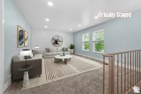 Spacious living area featuring light blue walls, recessed lighting, double windows, and light wood-finish railings