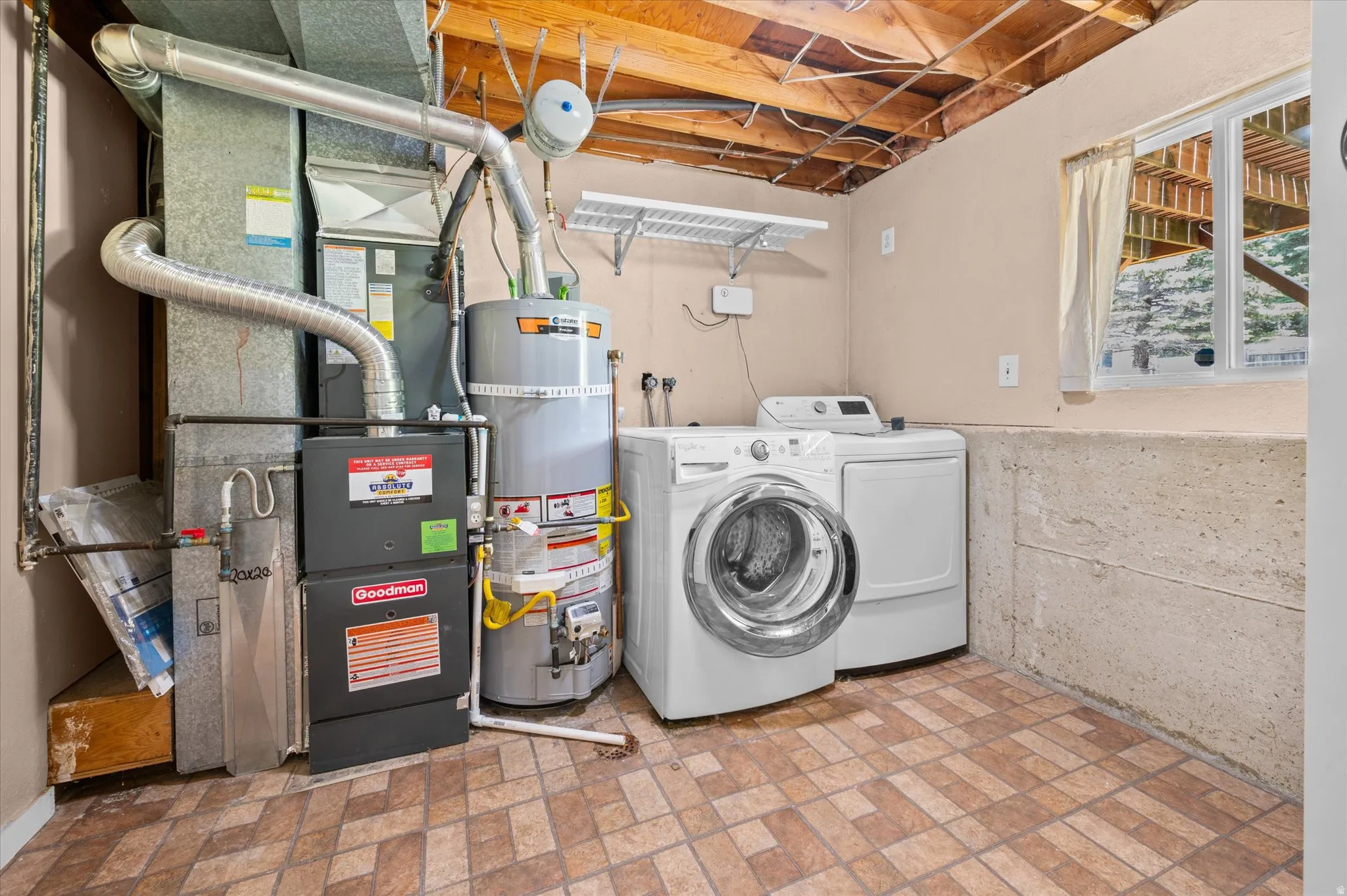 Utility area featuring a tiled floor, exposed ceiling joists, and a window for natural light
