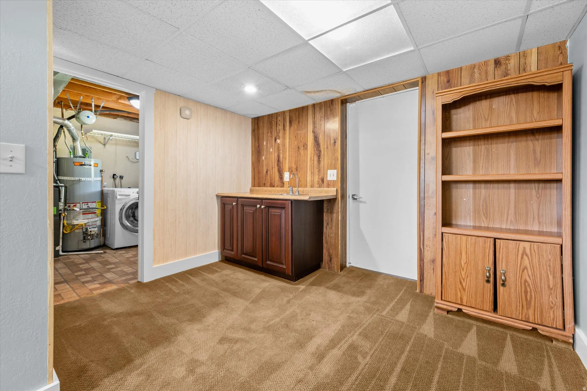 Bonus room featuring a sink, entrance to laundry room and walk out to garage