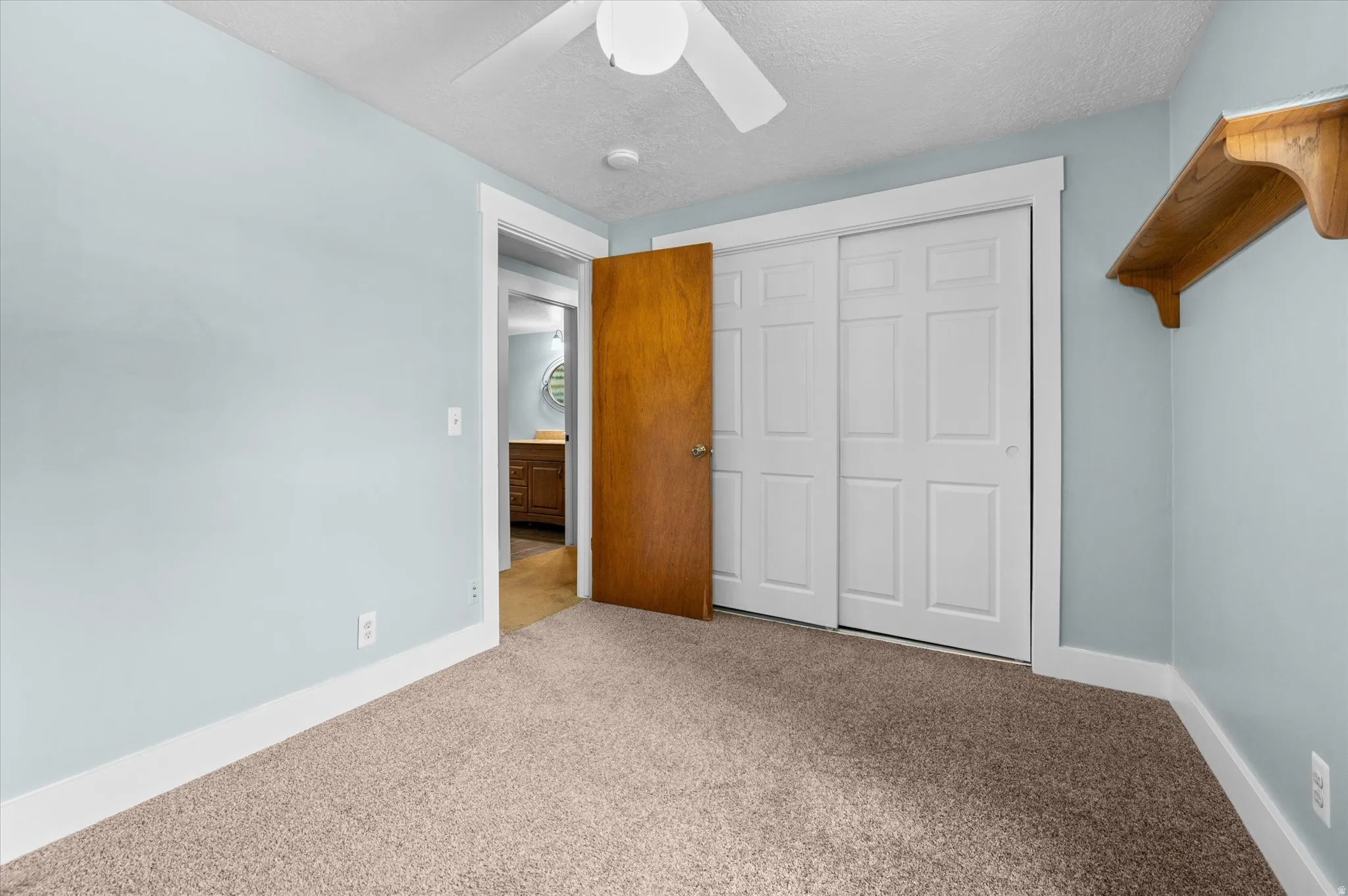 Carpeted Bedroom #4 with light blue walls, white baseboards, and white ceiling fan