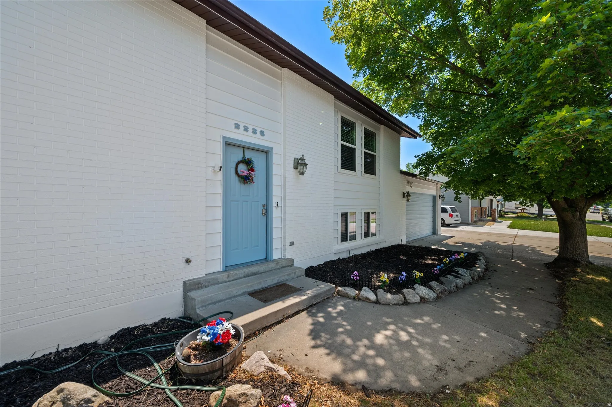 White brick exterior with a light blue entry door