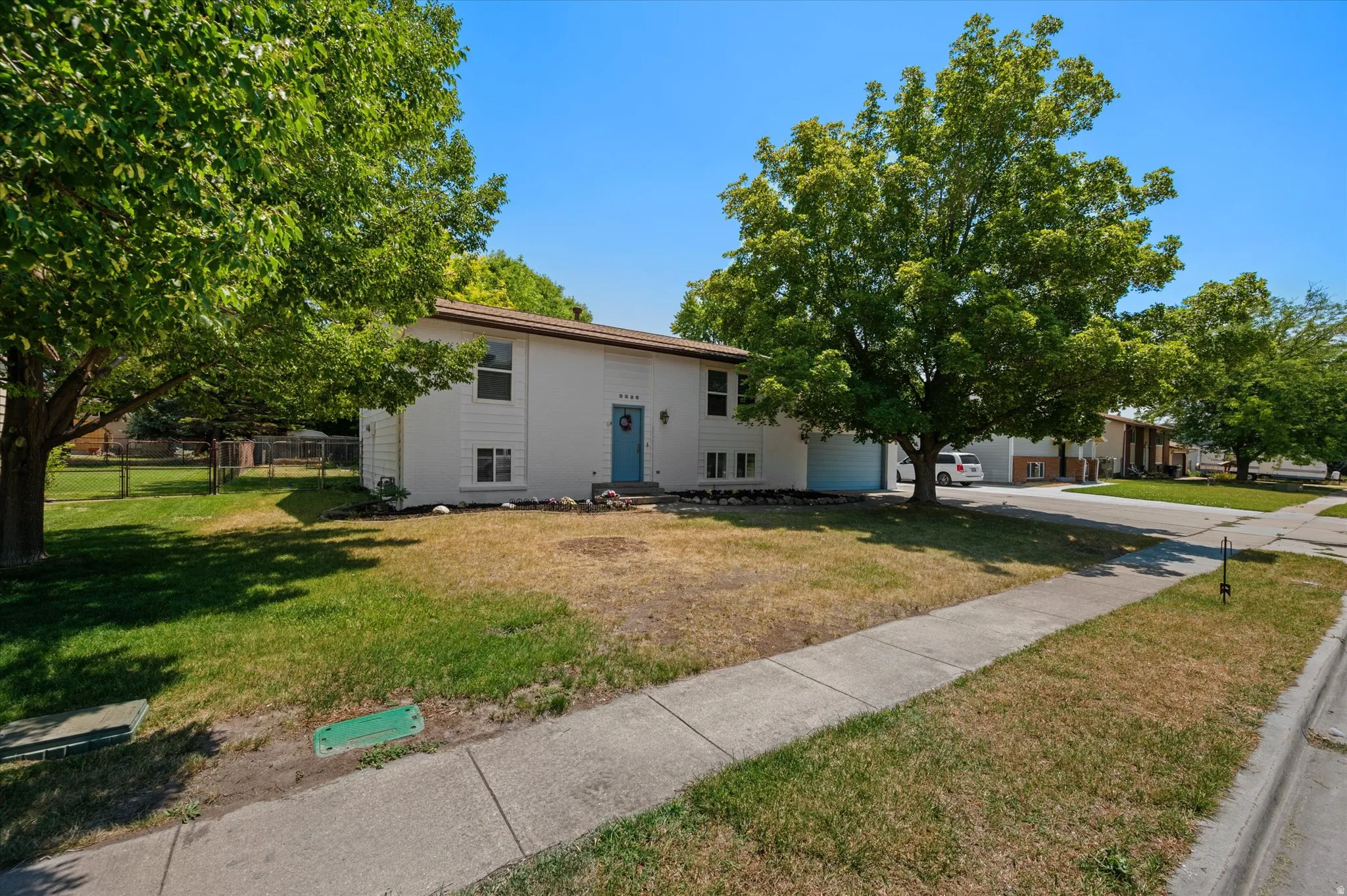 Two-story property featuring a white exterior with an accent blue front door