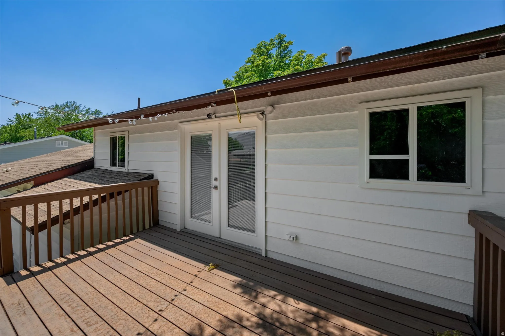 Expansive outdoor deck featuring wood-finish flooring and a wood railing