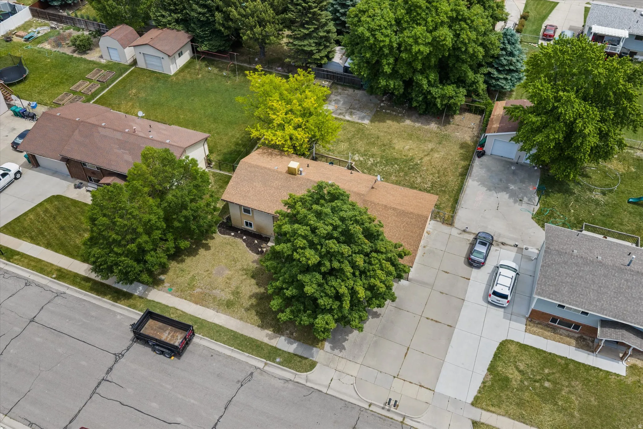 Residential property featuring a light brown shingle roof and a concrete driveway
