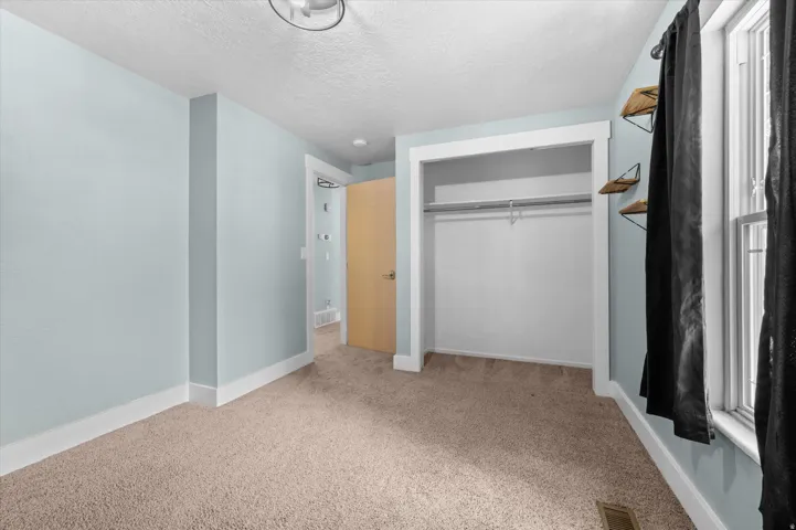 Bedroom #2 featuring light blue walls, a neutral-toned carpet, and white trim