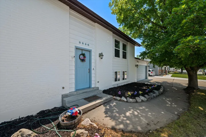 White brick exterior with a light blue entry door