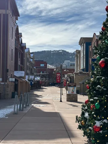 Pedestrian-friendly commercial thoroughfare with paved walkways framed by multi-story buildings featuring varied architectural styles