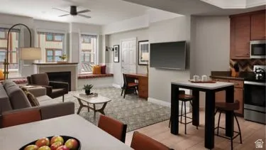 Open-concept living area featuring a fireplace with a stone surround, built-in window seating, a ceiling fan, and recessed lighting