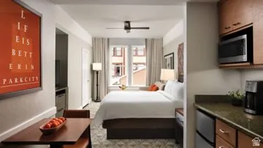 Compact studio layout with wood-finish flooring and a ceiling fan