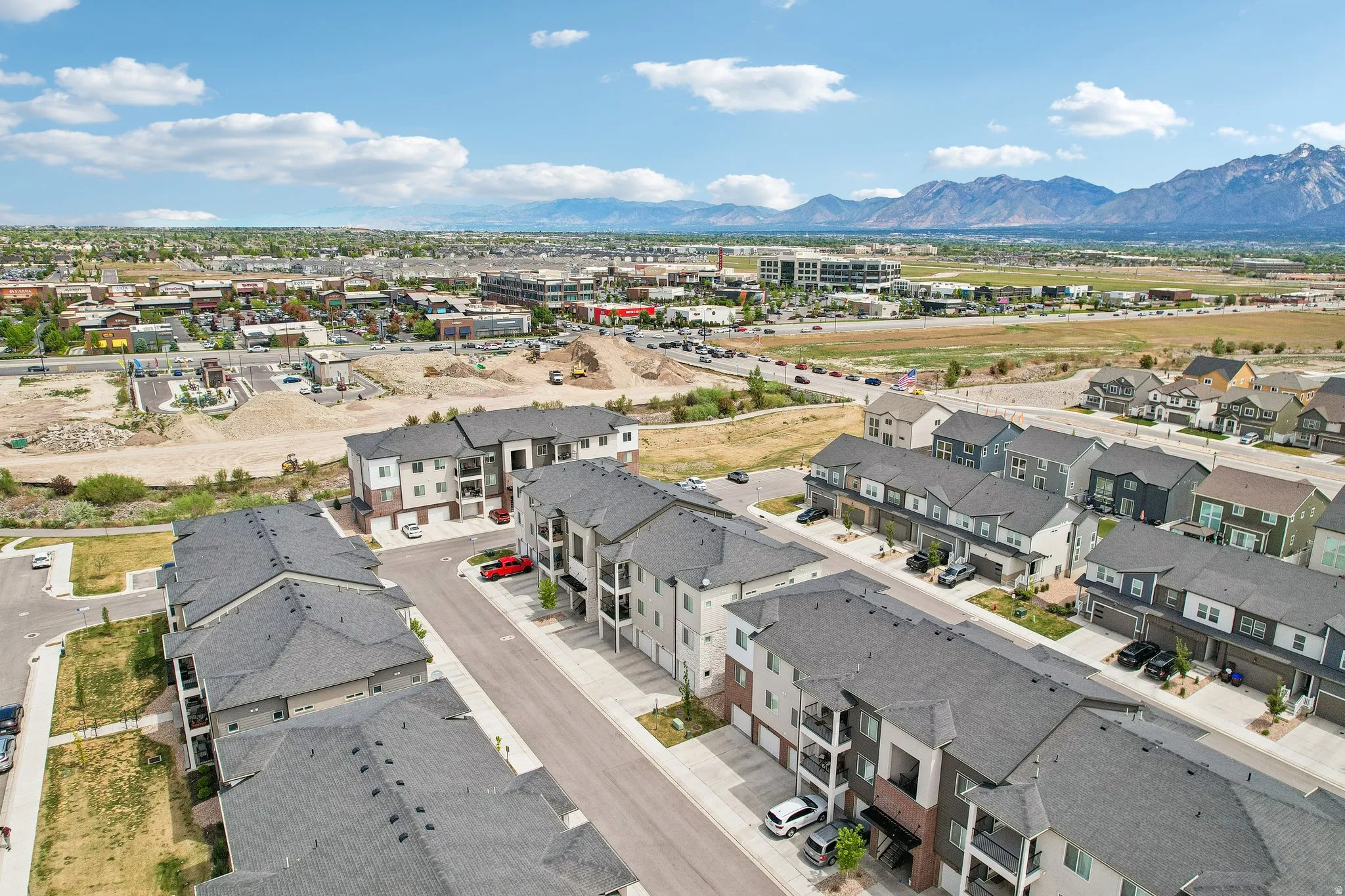 Expansive aerial view showcasing residential properties with a mix of townhomes and multi-story buildings