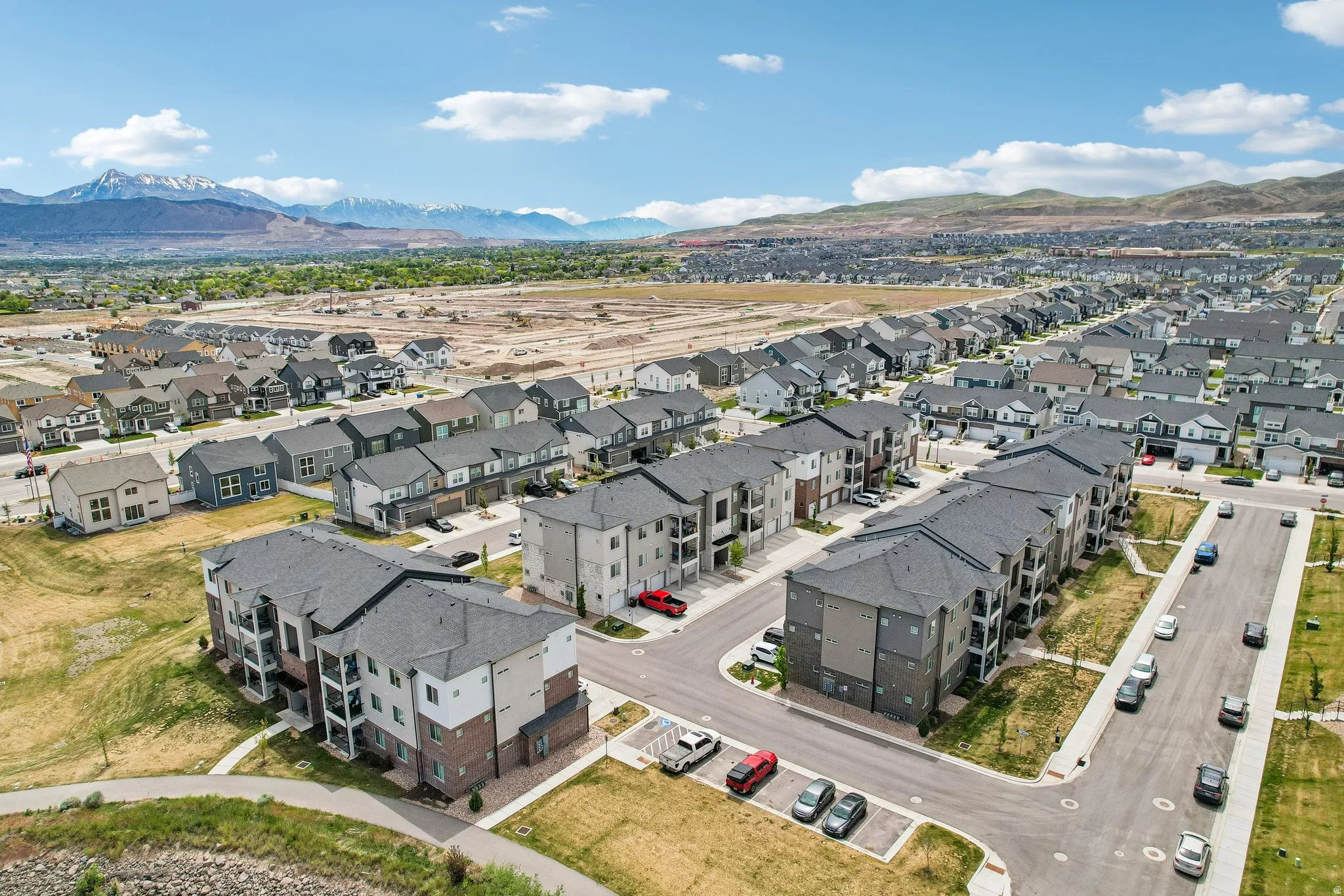 Expansive aerial view of a residential community featuring multi-story apartment buildings and single-family homes