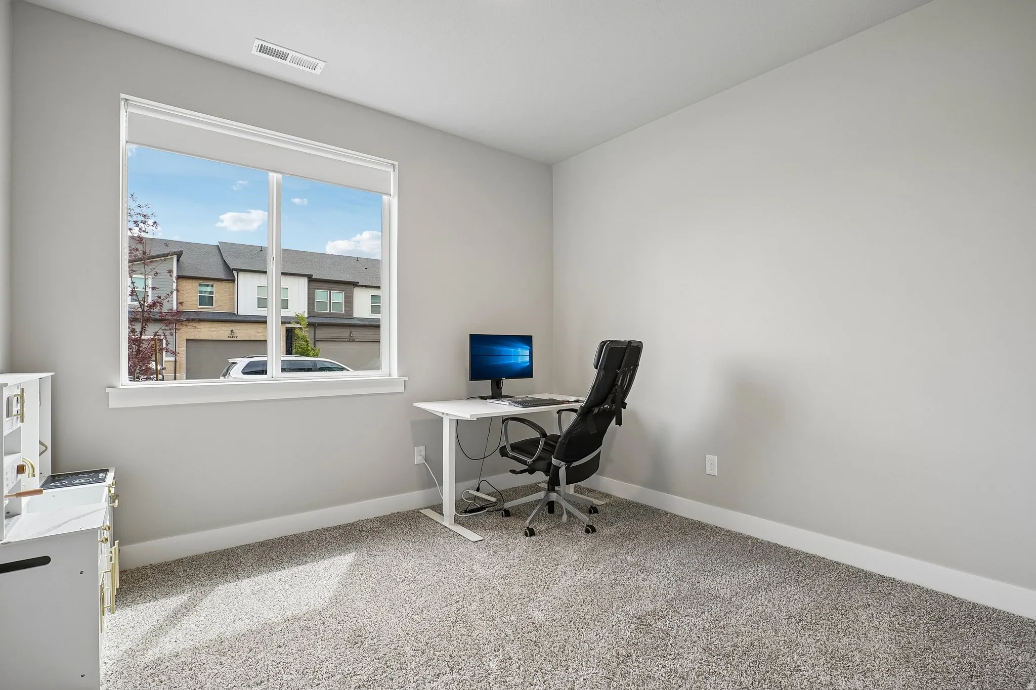 Bright room with neutral wall paint and carpeted flooring