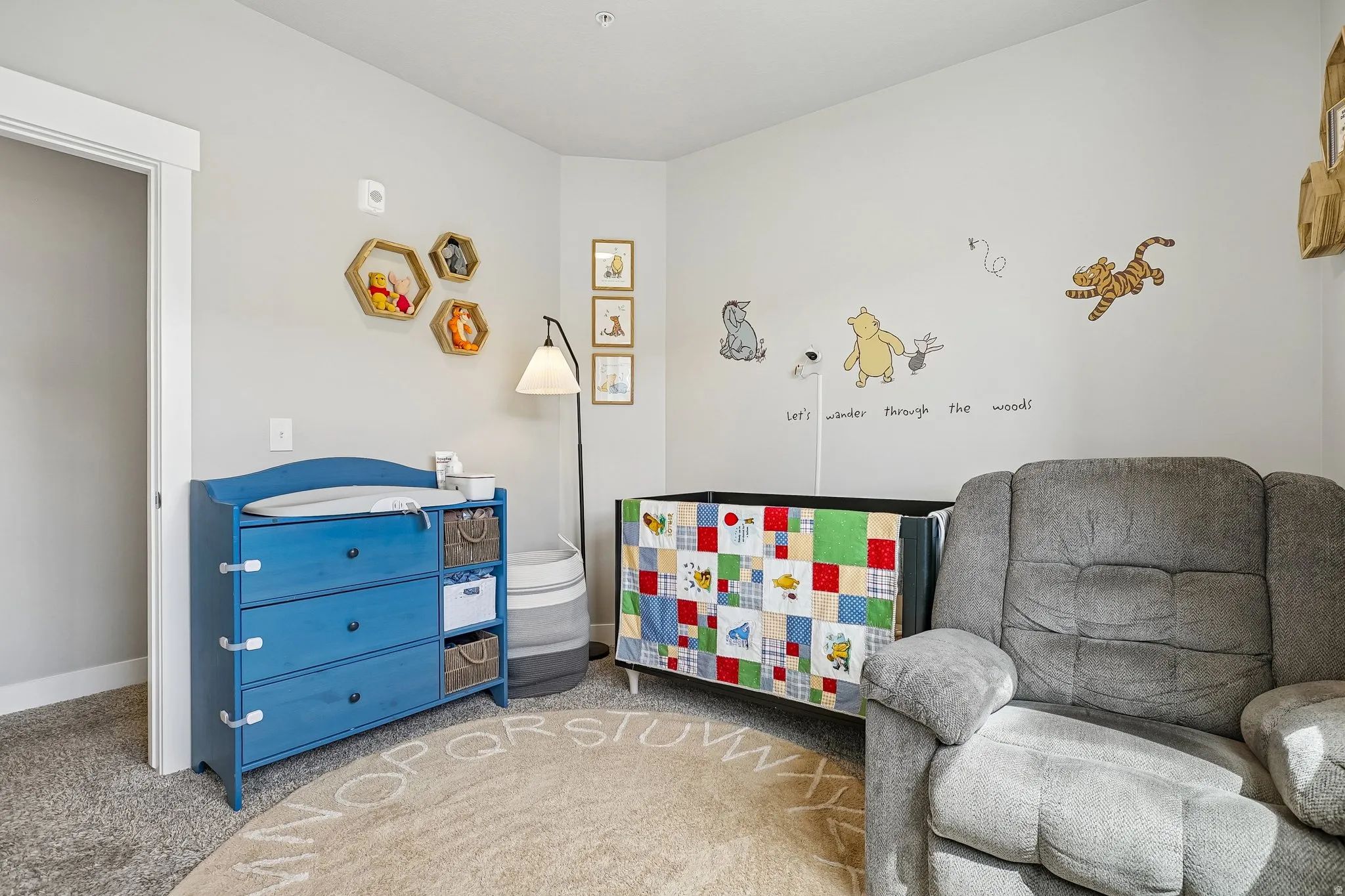 Light gray wall paint, recessed ceiling lighting, textured gray carpeting, and white baseboards