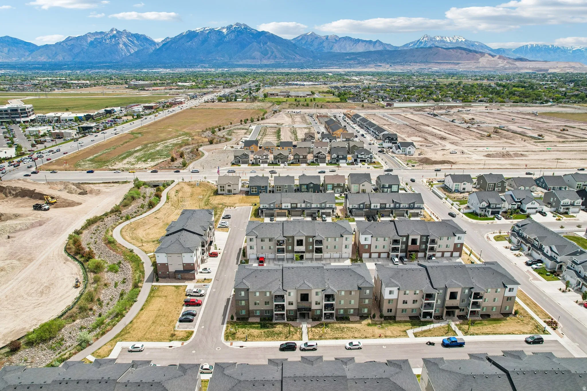 New construction community featuring multi-level apartment buildings and single-family homes