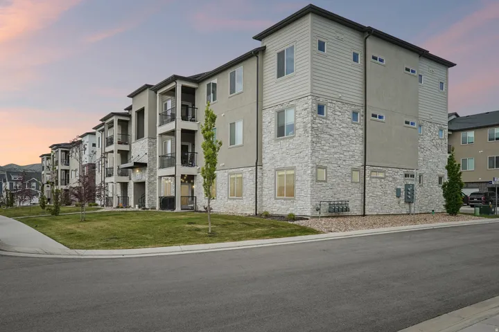 Modern apartment building with a multi-story facade featuring stone veneer and horizontal siding accents