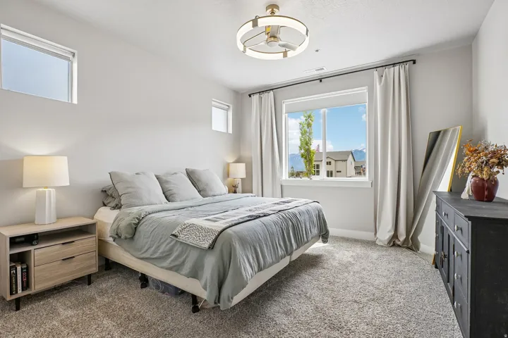 Light-colored carpeting and white walls complement the large window with expansive mountain scenery