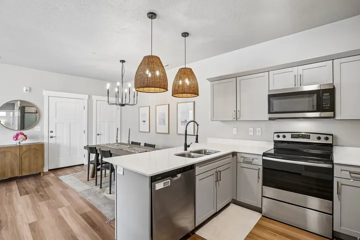 Contemporary kitchen featuring light gray cabinetry, stainless steel appliances, and white countertops