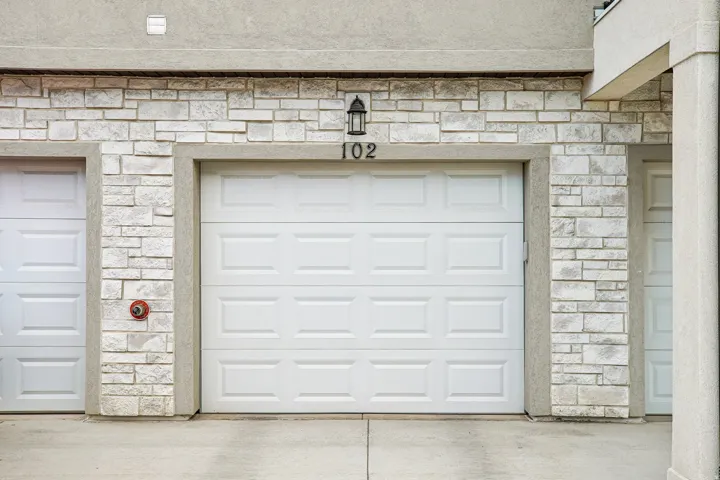White paneled garage door with stone veneer surround