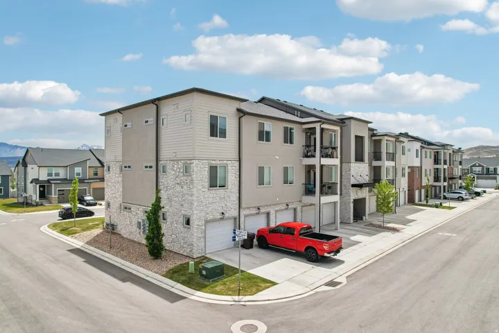 Modern multi-story residential building featuring a stone and siding exterior