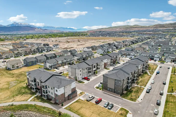 Expansive aerial view of a residential community featuring multi-story apartment buildings and single-family homes