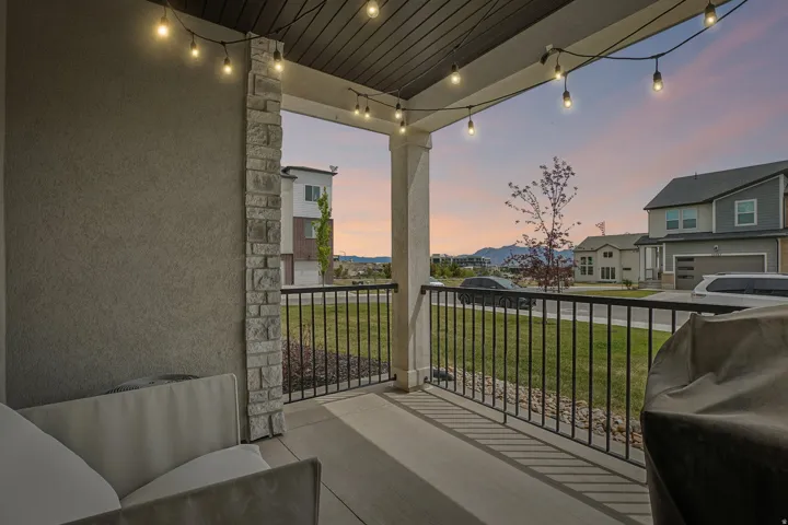 Covered porch featuring a textured stucco wall and a stone veneer column