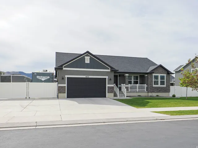 Contemporary single-story residence featuring a dark gray facade with stone accents